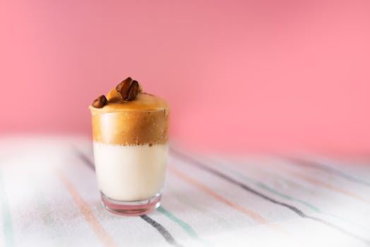 Aesthetic shot of dalgona coffee with creamy foam and topped with coffee beans.