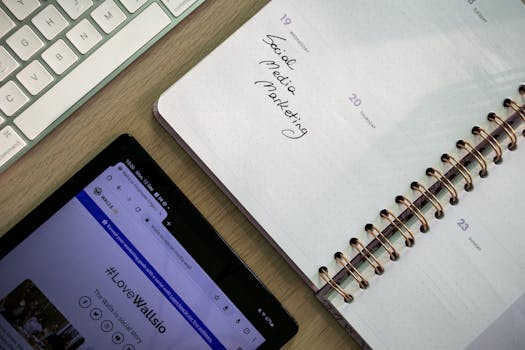 Top view of a notebook, tablet, and keyboard used for social media marketing planning.