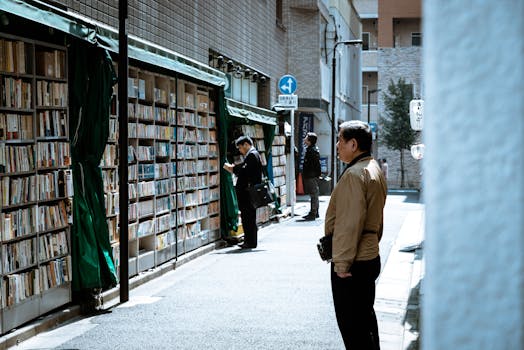 A bustling urban street with people browsing outdoor book displays, providing a unique shopping experience.