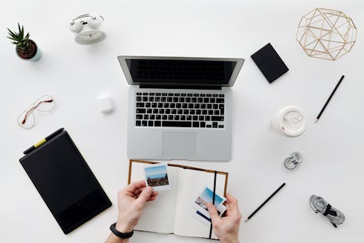 A top view of a minimalistic home office setup featuring a laptop, tablet, and accessories.