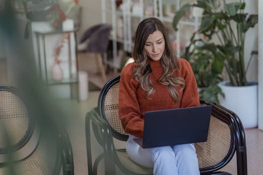 Woman in a casual setting working on a laptop with focus and determination.