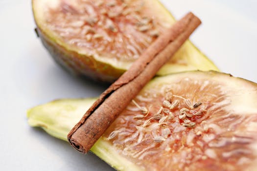 Slice of fresh fig paired with a cinnamon stick, showcasing culinary harmony.
