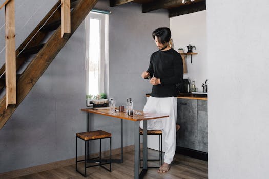 Man in modern kitchen preparing a beverage, promoting peaceful home routines.
