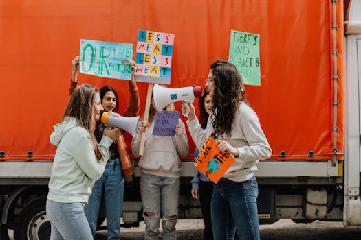 Group of young activists using megaphones and placards during a climate change protest outdoors.