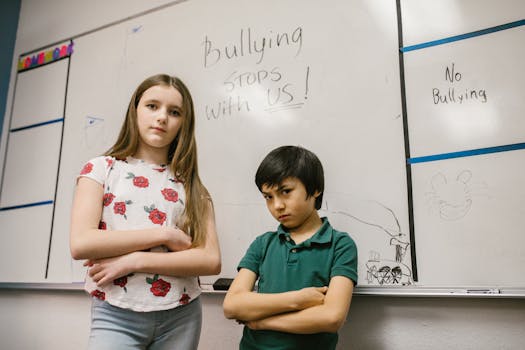 Children posing with 'Bullying Stops with Us!' message on classroom whiteboard.
