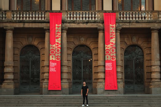 Elegant theater entrance with vibrant 'Don Giovanni' banners and a lone figure on the steps.