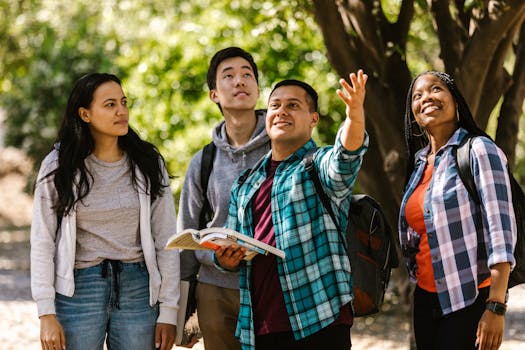Four diverse college students outdoors, studying and interacting with nature.