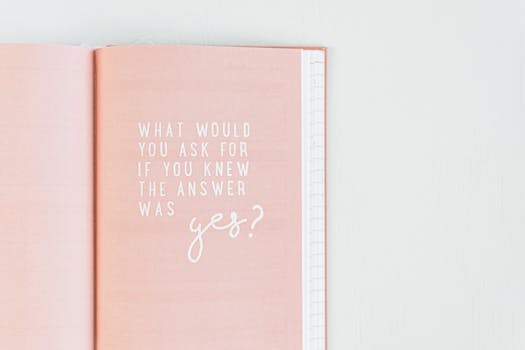 Open pink notebook with an inspirational quote in white text.