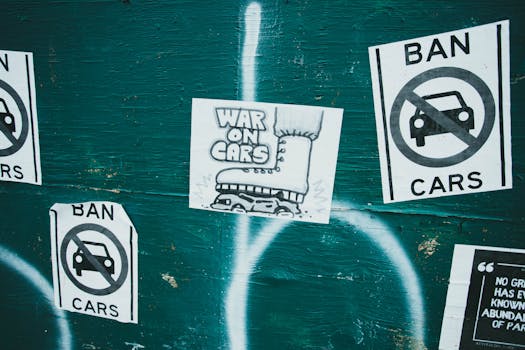 <a href='https://amzn.to/46GdUP7' target='_blank'></img>Posters</a> advocating a car ban and promoting 'War on Cars' theme on an urban green wall.