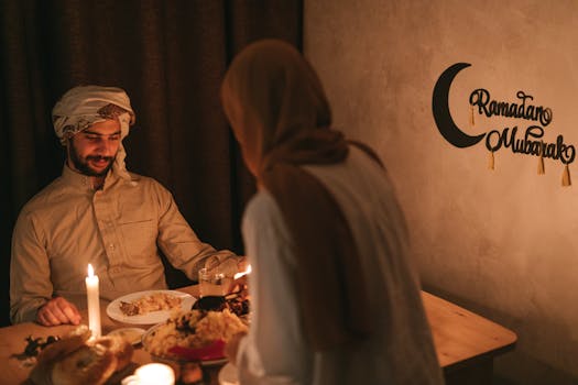 A couple enjoying a festive Ramadan dinner by candlelight, embracing cultural and traditional attire.