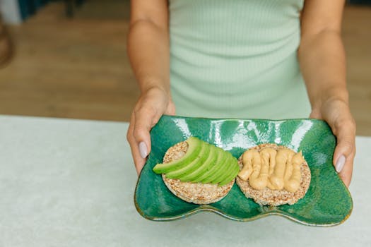 A visually appealing arrangement of avocado and hummus on toast, presented on a green ceramic plate.