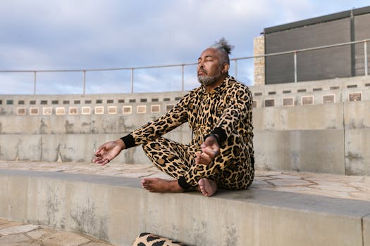 Man in leopard print attire meditating outdoors, eyes closed, promoting wellness.