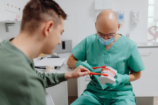 Dentist demonstrating proper brushing technique to patient using dental model.