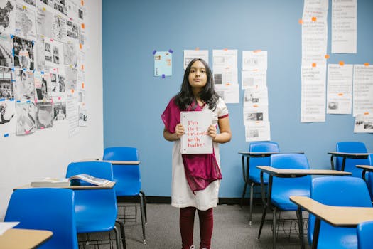 A young girl holding a sign promoting anti-bullying in an empty classroom, emphasizing awareness.
