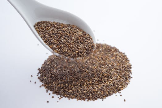 A close-up shot of <a href='https://amzn.to/48FohoW' target='_blank'></img>chia seeds</a> pouring from a white ceramic spoon onto a white surface.