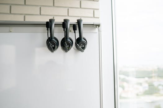 Set of three headsets on a whiteboard, ideal for call centers or tech environments.