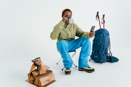 An adult hiker sitting and enjoying a coffee break with backpacking gear indoors.