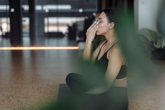 Peaceful woman practicing yoga indoors with eyes closed, focusing on breathing and relaxation.