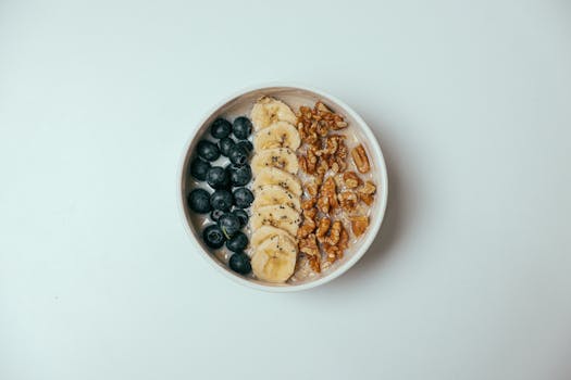 Delicious oatmeal bowl topped with blueberries, bananas, and walnuts.